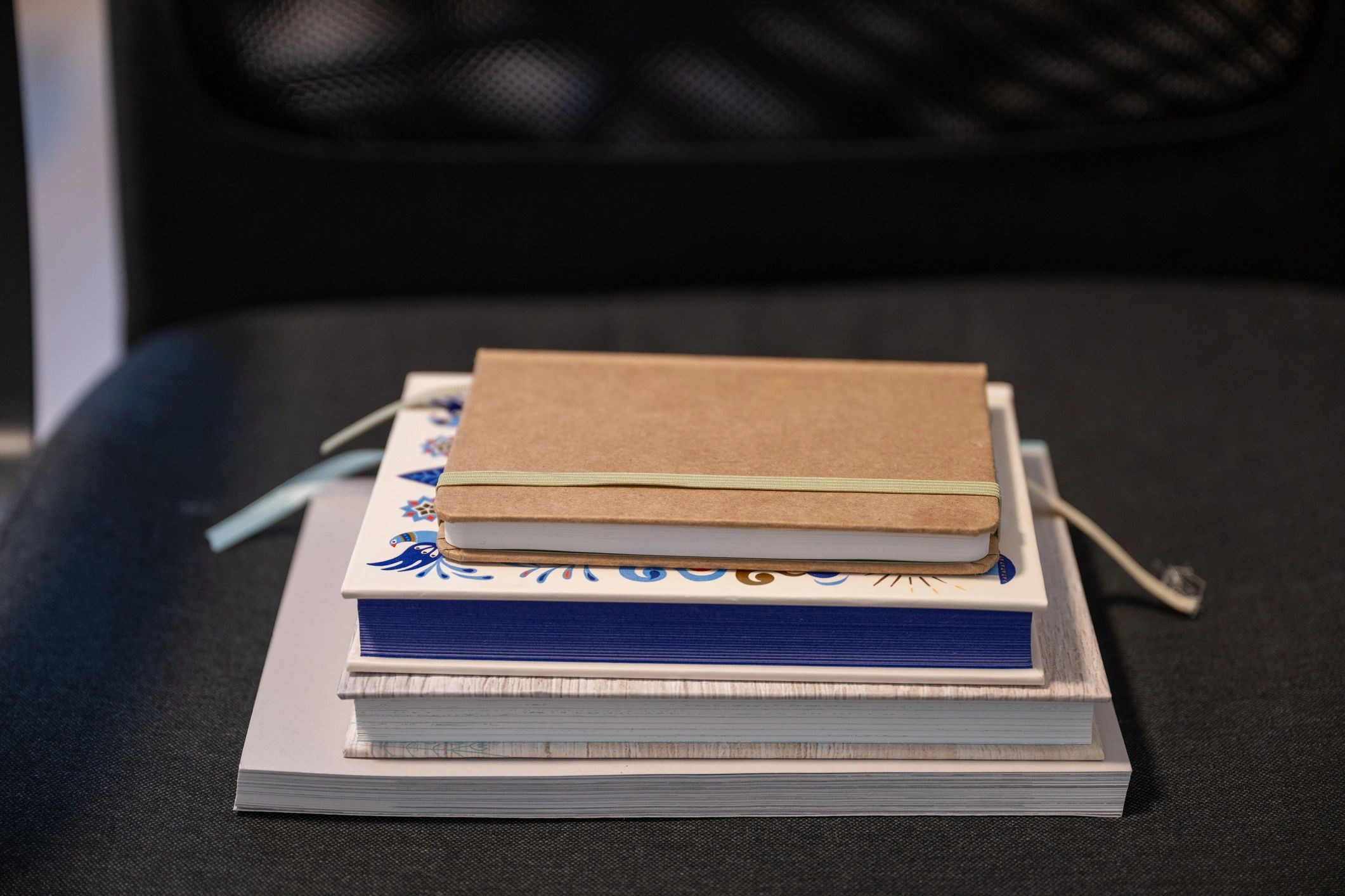Minimal stack of notebooks on a dark background.