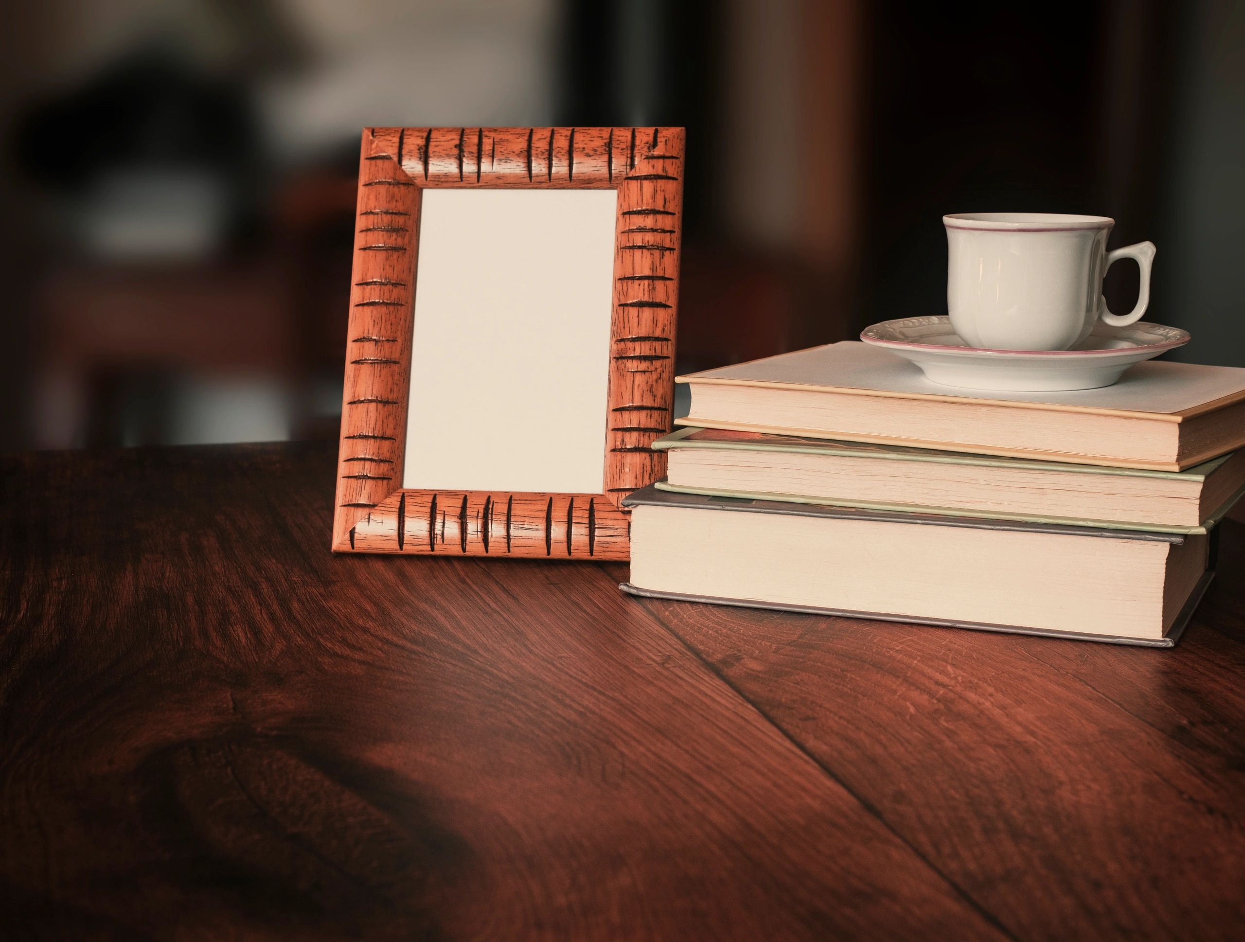 Desk scene with a picture frame mockup, books, and a coffee cup.